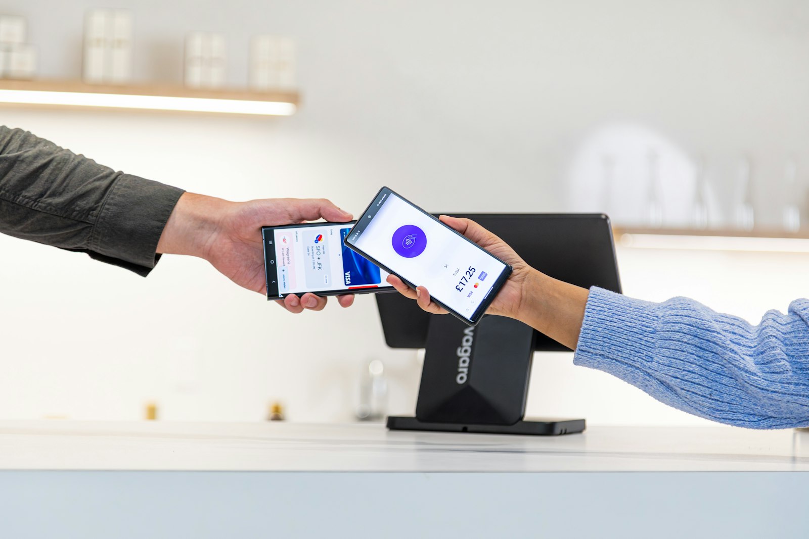 Un acheteur règle une commande en approchant son téléphone d'un terminal de paiement